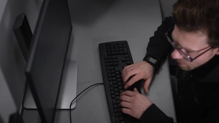 Poster - Top view of a man with glasses, who wore on his hand smart watches, body black sweatshirt, he was married, as put a ring on his finger. The man quickly typing the text on keyboard,