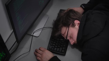 Poster - Young student of Faculty on Information Technology is sleeping on keyboard in frint of computer monitor after hard studying. Man is tired and resting before the classes after learning all night long.