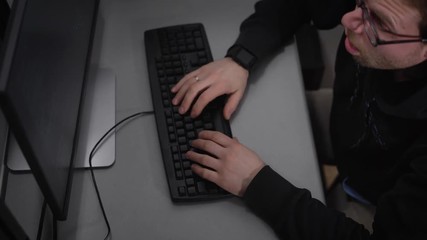 Poster - View of the a man in a black jacket with a hood, who fell asleep for a while, as long worked. But at one point he abruptly wakes up, puts on glasses with a dark rim