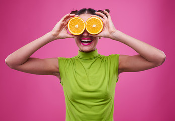 funny shot of girl with two pieces of orage on eyes