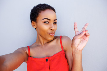 Wall Mural - young woman taking selfie with peace hand sign