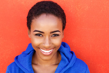 Wall Mural - beautiful young black fashion woman smiling against red wall