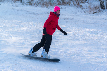 Girl snowboarding on the mountain slope