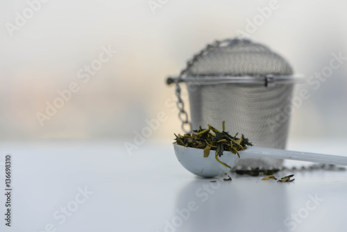Fotografie, Obraz Dry tea leaves in a teaspoon with Tea strainer