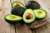 Fototapeta  - Fresh sliced avocado on wooden table. Vegetarian  food concept.