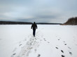 Solitary man on snowy frozen river