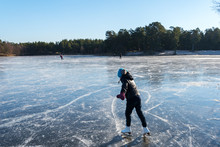 Skaters On Frozen Lake.