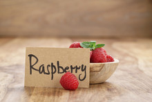 Bowl With Raspberries With Paper Card On Wood Table, Simple Photo