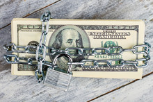 Locked Dollars On Wooden Background. Protect Your Savings.
