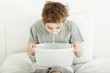 Young boy sitting in bed vomiting into a bowl