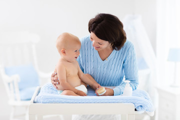 Wall Mural - Mother changing diaper to baby boy