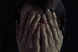 Concept of fear, domestic violence. Woman covers her face her hands. Image cut into many pieces for more drama.