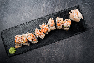 Wall Mural - Tasty and delicious traditional japanese sushi roll with seafood and fish on black wooden background