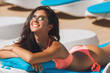 Beautiful girl on the beach relaxing, having a natural tan near the seaside