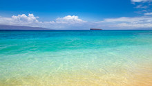Blue Water At Makena Beach, Maui, Hawaii With Molokini Crater At The Horizon. Molokini Is A Crescent Shaped Island, The Tip Of An Underwater Volcano And A Snorkelling And Diving Destination 