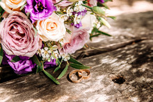 Wedding Lilacbouquet And Rings On Wooden Surface. Wedding Rings