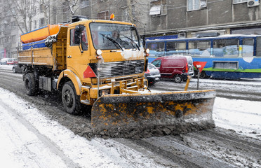 Snow remover truck cleaning city streets in snow storm