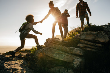Wall Mural - young people on mountain hike at sunset