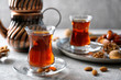 Turkish tea in traditional glass with nuts on table closeup