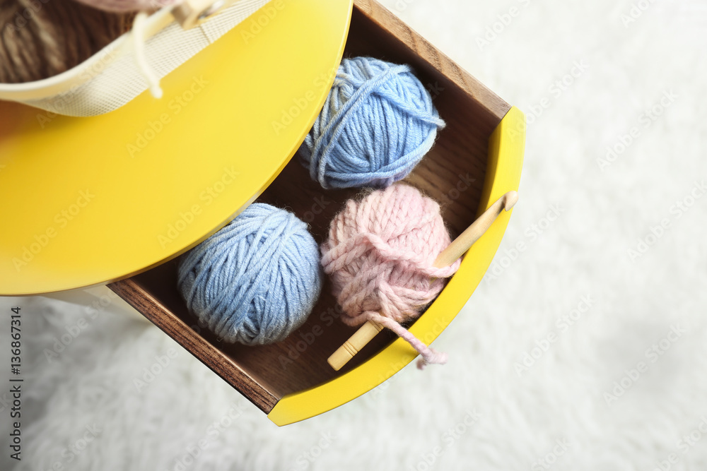Knitting yarn and hook in yellow table drawer, closeup