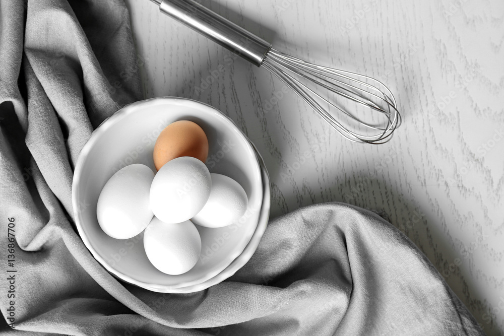 Raw eggs in bowl on kitchen table