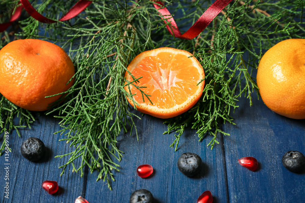 Composition of tangerine and coniferous branches, closeup