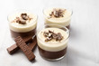 No-bake layered chocolate mousse and cheesecake with chocolate covered wafer cookie crumbs topping. In clear glass dessert bowls. On white background. Great recipe, creamy, light and not too sweet!