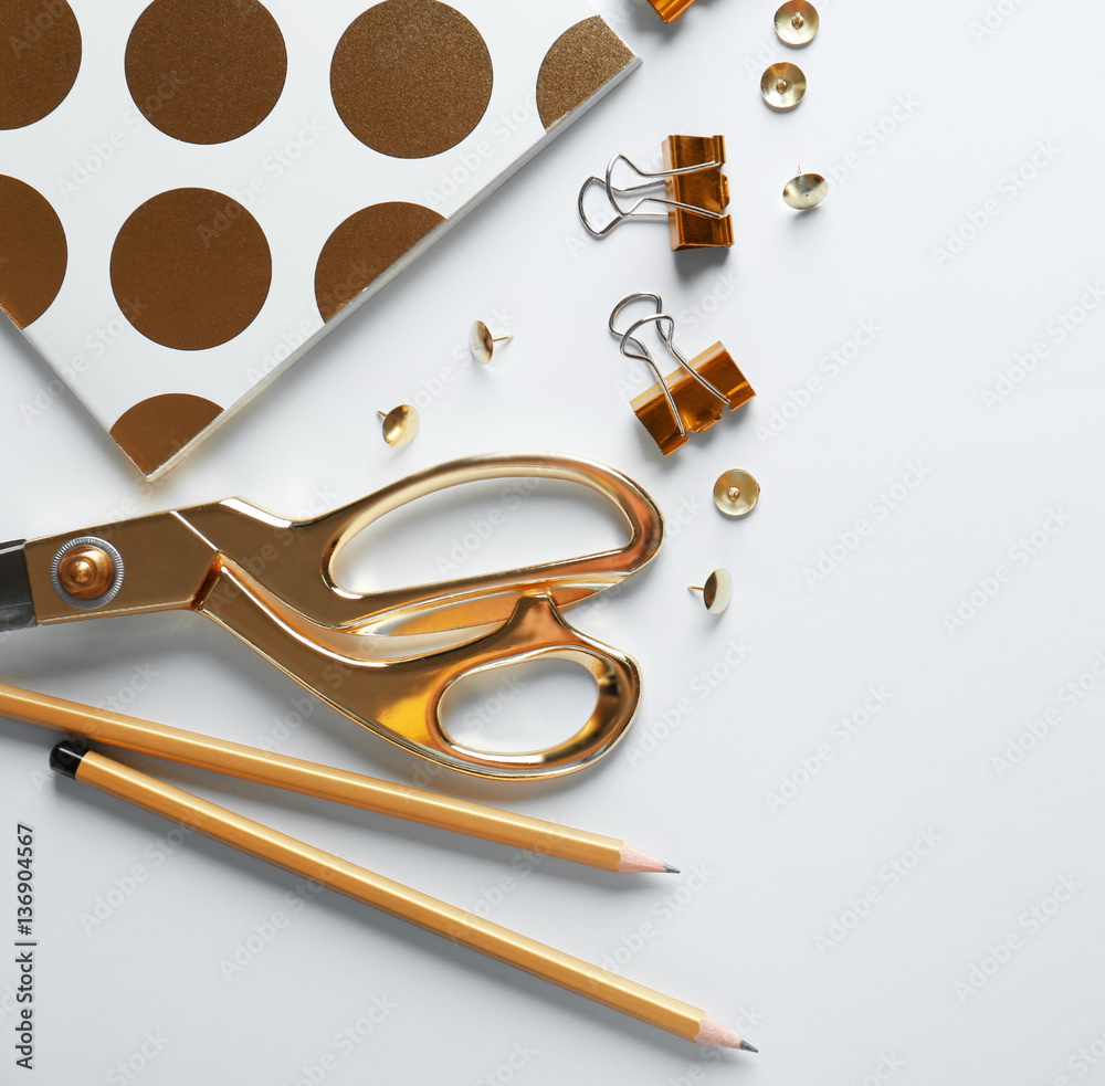 Flat lay of golden stationery with keyboard on white background