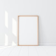 © customdesigner - Wooden Frame with Poster Mockup standing on the white floor. 3d rendering