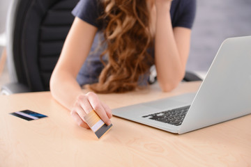 Sticker - Young woman shopping online with credit card and laptop at home