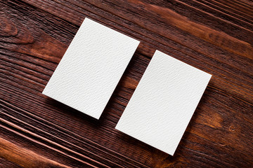 Wall Mural - Closeup mockup of two blank vertical business cards at brown woo