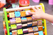 Close up of toddler’s hands playing with colorful educational toy