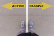 Active vs Passive text arrows on asphalt ground, feet and shoes