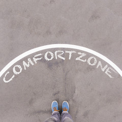 Wall Mural - Comfort zone text on asphalt ground, feet and shoes on floor