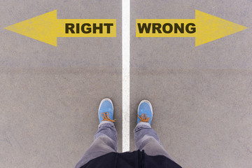 Wall Mural - Right vs Wrong text arrows on asphalt ground, feet and shoes on