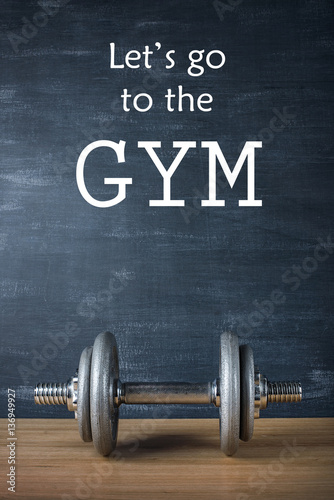 Papel de parede metal barbell on dark gray background and motivation text let's go to the gym