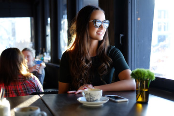 Smiling brunette woman in a cafe.