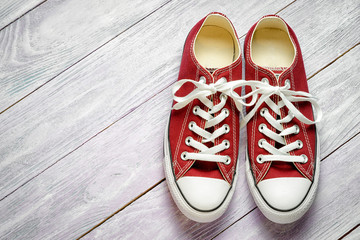 Traditional new vinous gumshoes with white laces on a wooden background, Top view, copy space for your text.