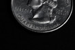 Close up of quarter dollar coin on black background - business concept