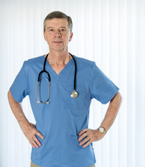 Senior doctor in scrubs facing camera