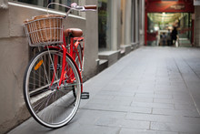 A Red Bicycle Parked In A Laneway
