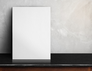 Leinwandbilder - Blank White paper poster on black marble table at grey concrete