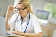 © goodluz - Portrait of doctor working on laptop