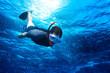 young man snorkeling down into the deep blue ocean sea background