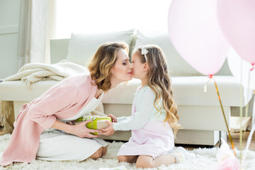 girl presenting gift to mother