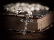 Closeup Of Iron Christian Cross With Holy Bible.