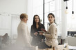 © Maskot - Businesswomen discussing while standing in office