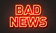 Bad news neon sign on brick wall background.