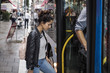 © Maskot - Woman and man boarding bus at city