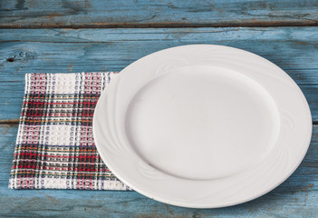 Empty plate with napkin on blue wooden table